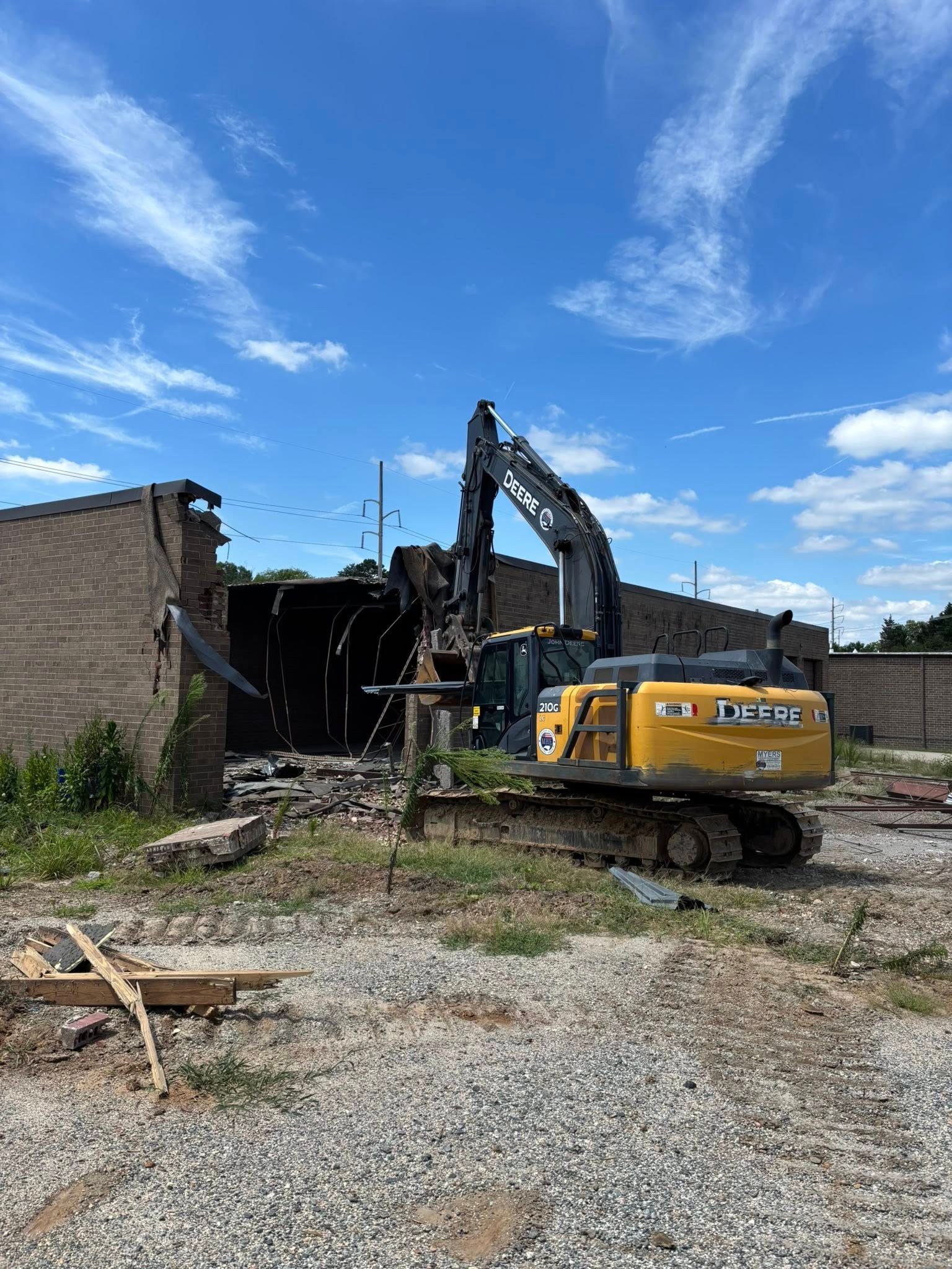Excavator demolishing a brick building