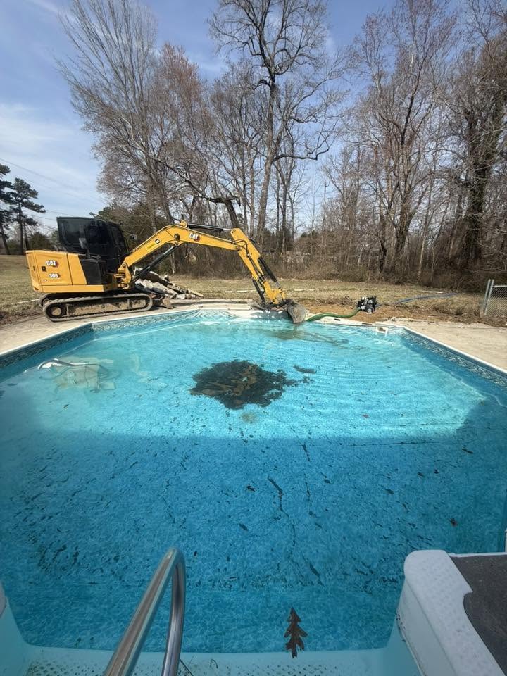 Excavator removing a backyard swimming pool